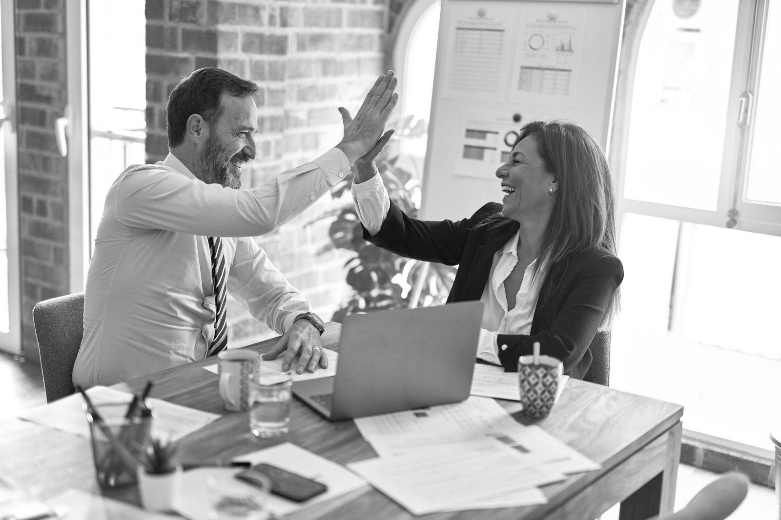 Two colleagues celebrating a win at work